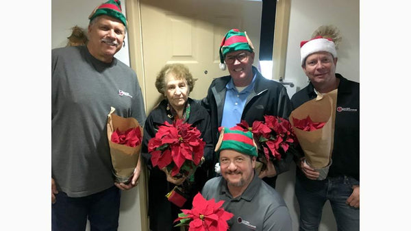 Jamboree and URSG hand out poinsettias to seniors at Heritage Villas in Mission Viejo.
